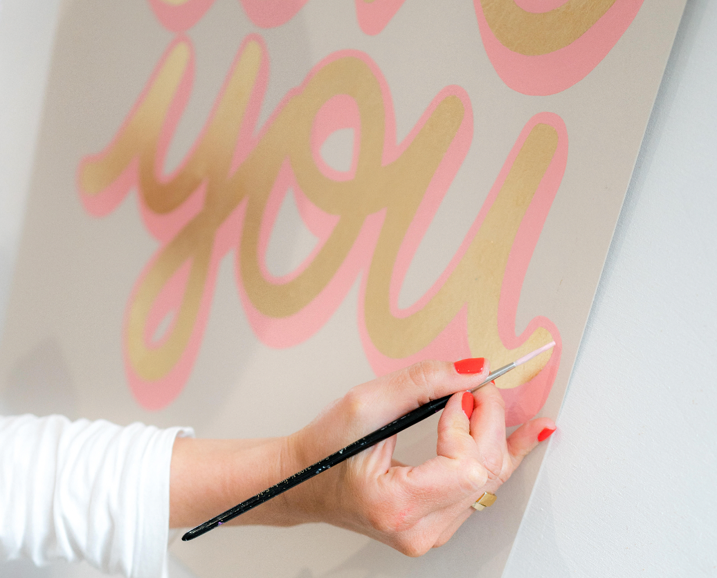 Daisy Emerson, woman artist  painting original art work, typography in gold and pink that says "you"